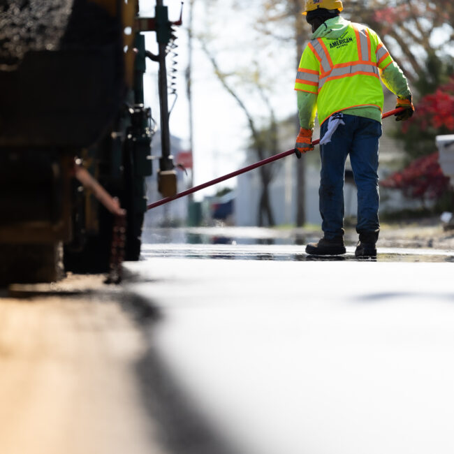 Earle American employee sealing cracks on road