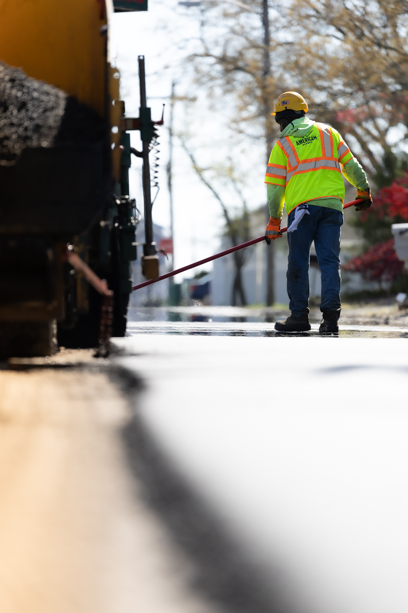 Earle American employee sealing cracks on road