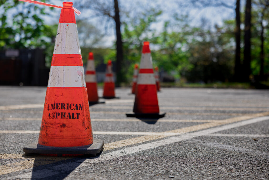 Earle American cones placed on parking surface for asphalt repair job