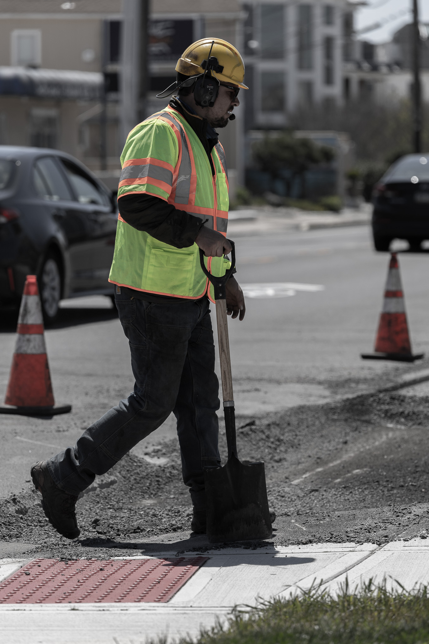 Vehicle and worker with vest paving surface
