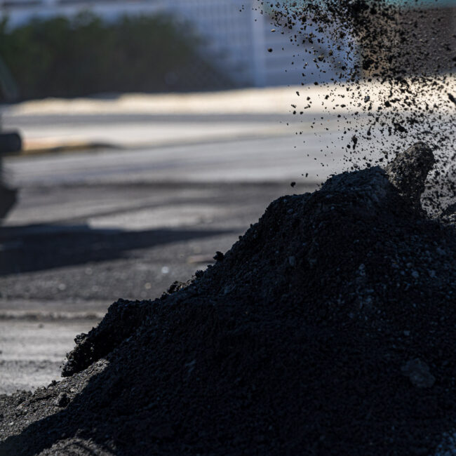Soil-being-moved-into-pile-sitting-on-asphalt-parking-lot