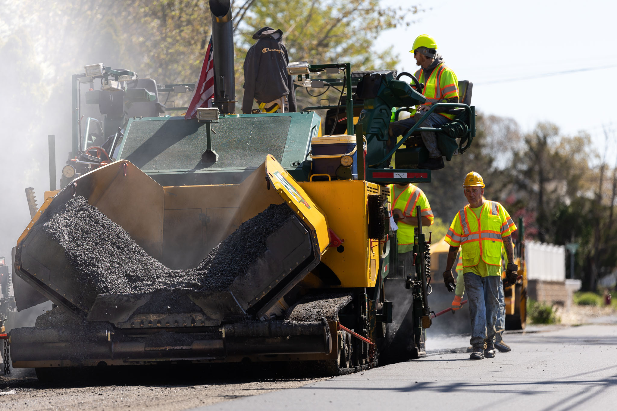 Contractors using machine to lay fresh asphalt