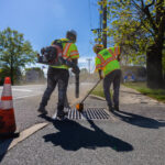 Parking lot contractors cleaning grid on storm drain