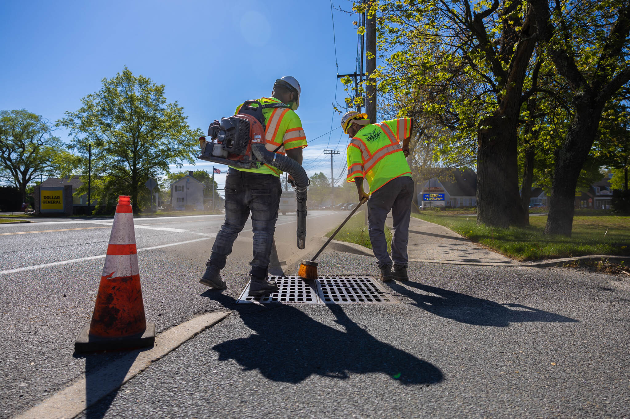Parking lot contractors cleaning grid on storm drain