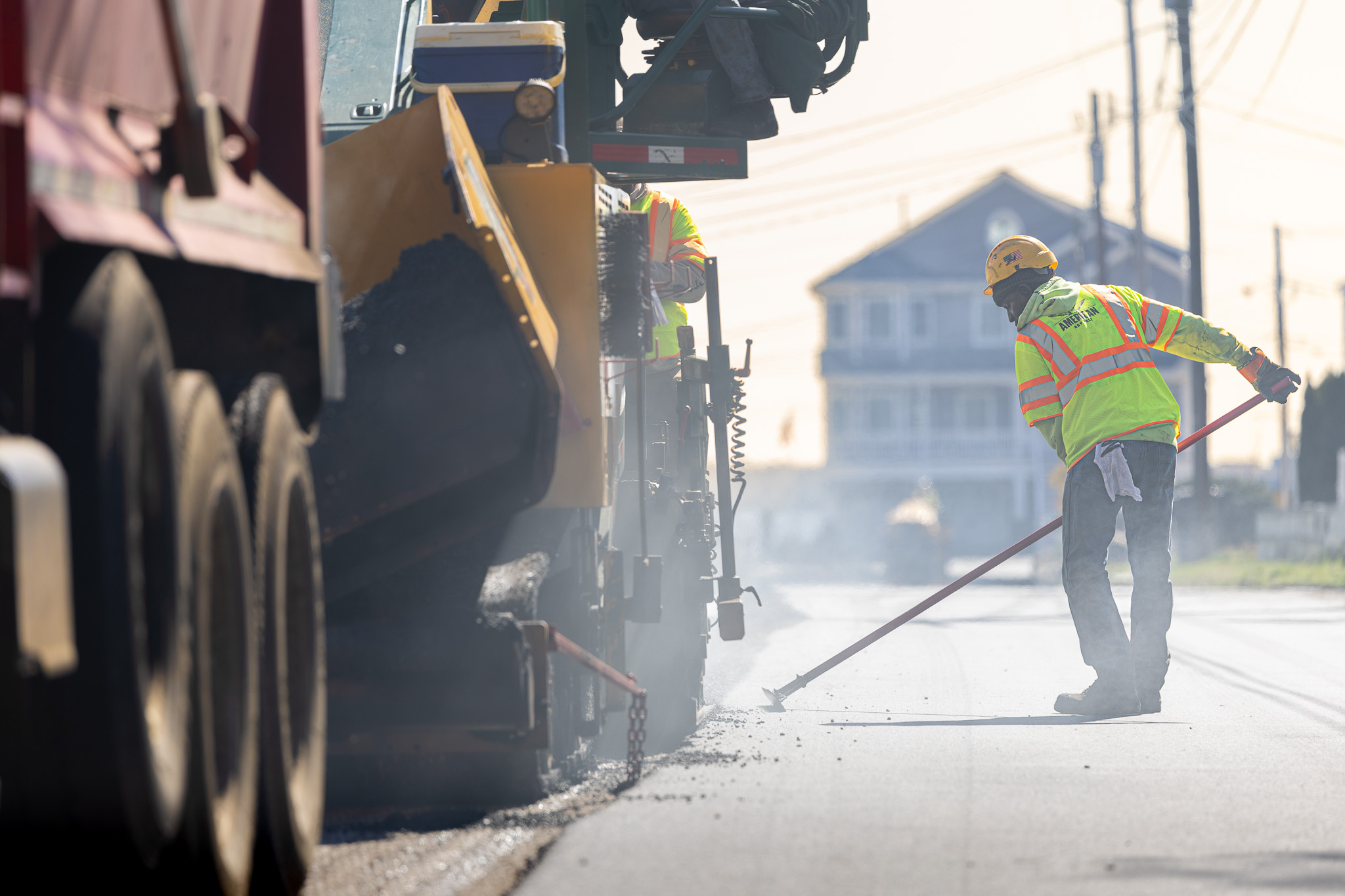 Worker and machinery performing road repairs